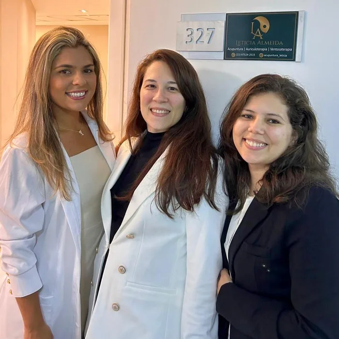 Equipe Trix com Letícia Almeida na porta do consultório, ao lado da placa, no dia da inauguração